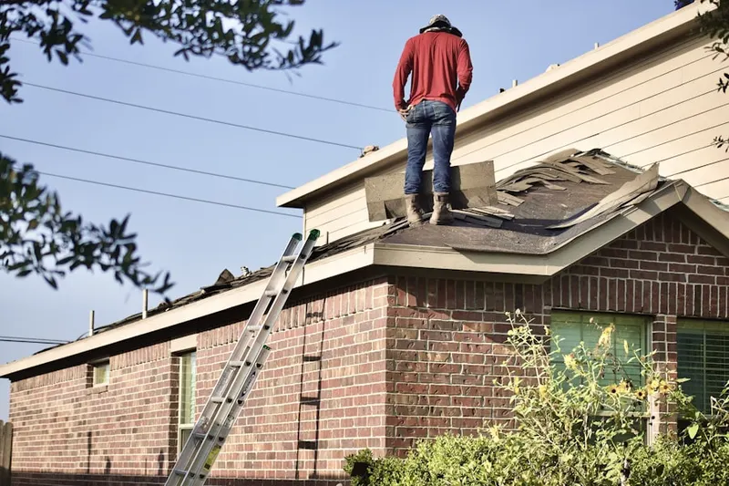 Professional roofer working on a residential roof in Post Oak Village